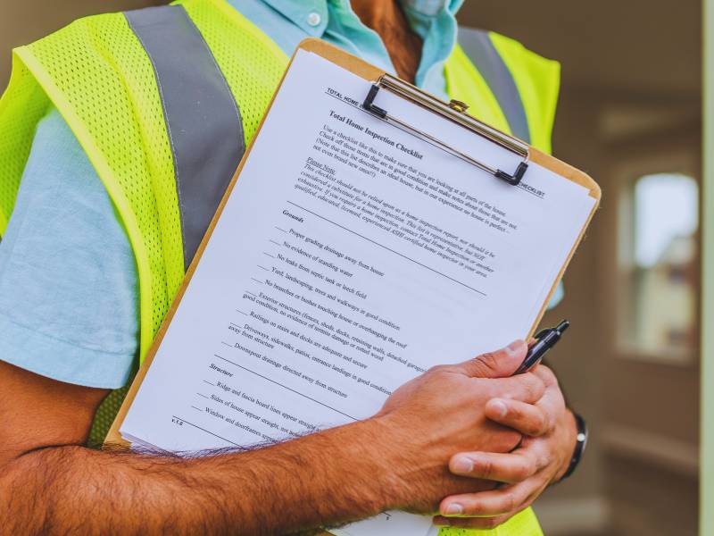 Home buyer and inspector standing outside a house